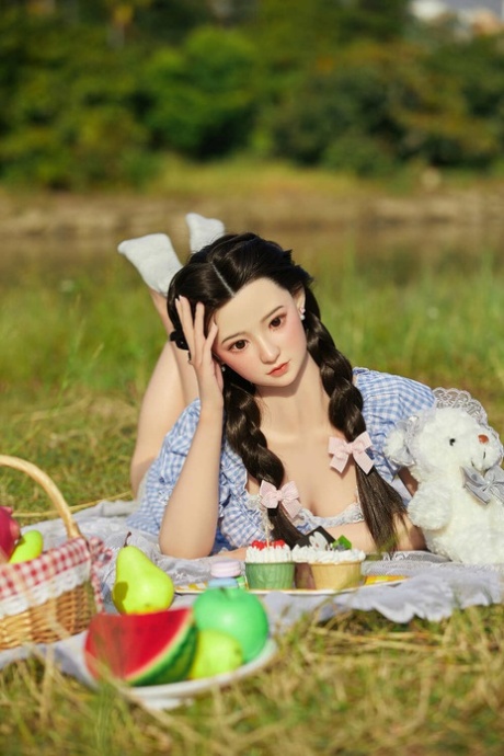 Kleine Aziatische sekspop Kitto poseert in haar schattige jurk tijdens een picknick