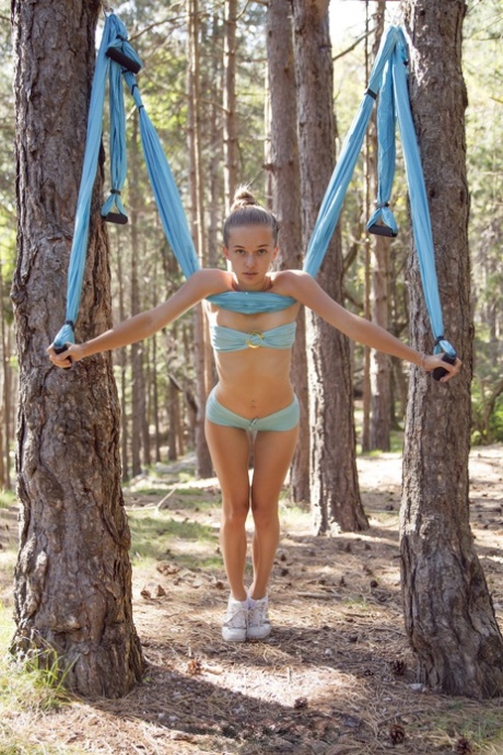 La snella Milena Angel posa nuda e si dondola nel bosco