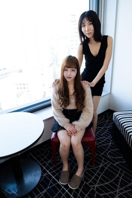Las lesbianas japonesas Ai Nakamori y Kayo Miura comparten un juguete morado en el sofá