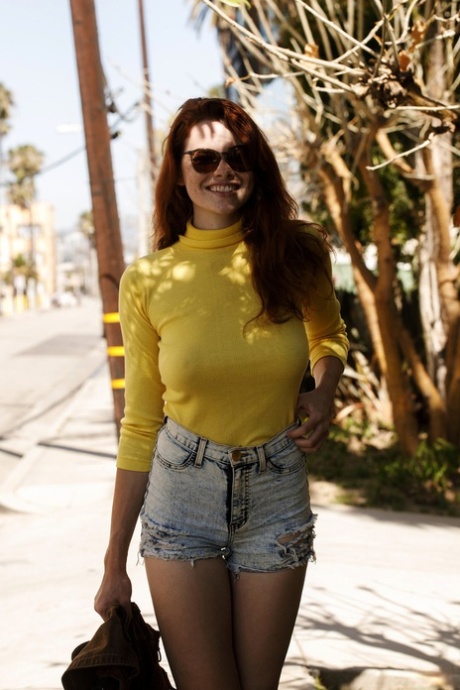Babe Sabrina Lynn drażni się swoimi twardymi sutkami przez żółty sweter na zewnątrz