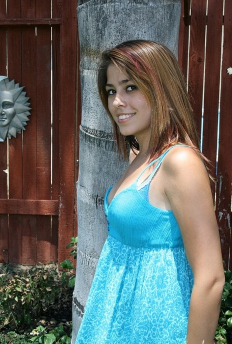 Breanna se quita el vestido largo y posa en ropa interior azul al aire libre