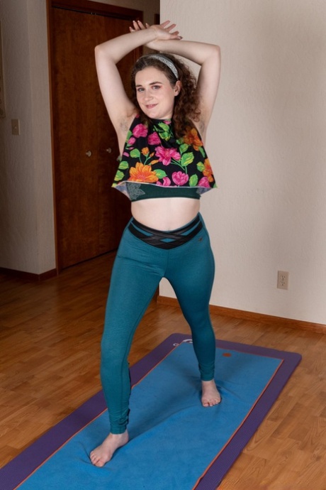 La brune Caralynn Rose se déshabille et frotte ses poils sur un tapis de yoga.