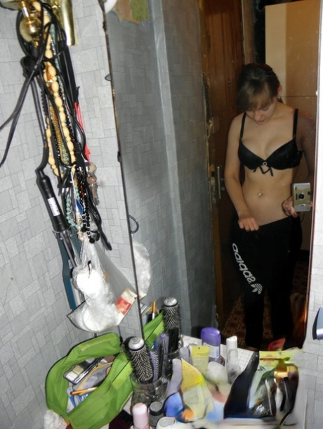 Amateurmeisje met een lekker kontje stript en poseert in de spiegel