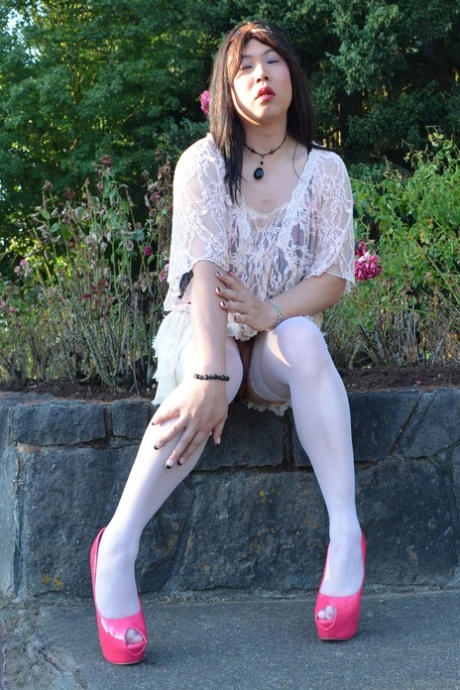 Slutty Asian shemale poses in a provocative outfit & high heels in public