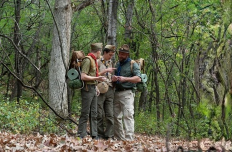 2 scouts excités écartent les jambes pour la bite de leur chef scout dans une tente