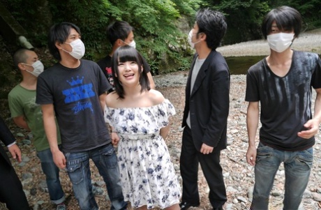 A menina japonesa Tsuna Kimura fica com tonturas na boca enquanto dá a cabeça ao ar livre