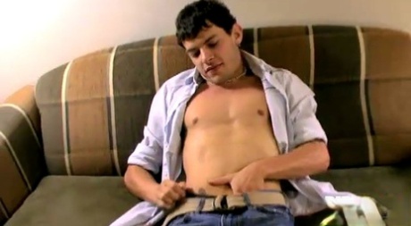 Sexiga gay Brian Taylor tar av sig sina jeans och onanerar naken på en soffa
