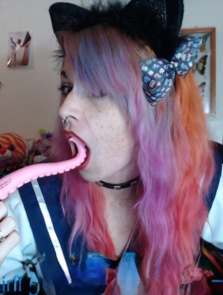 Une fille coquine en jupe, Lady The Tramp, lèche sa collection de sex toys.