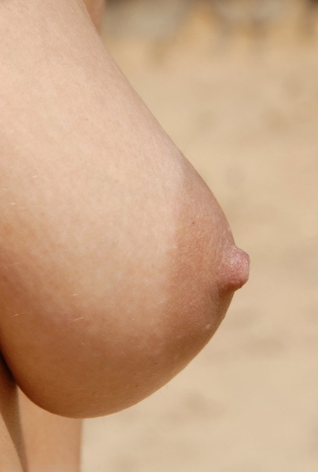 Teen Stany poserer nøgen på en sandstrand og viser sin behårede fisse tæt på