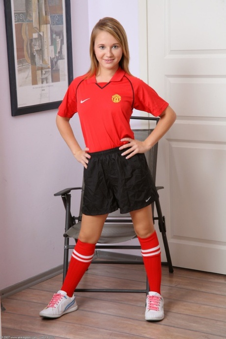 A pequena jogadora de futebol Olga tira o uniforme e abre a sua rata depilada