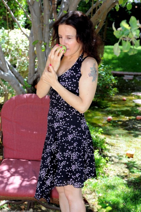Lustful GILF Marie stripping and posing by a tree in the backyard