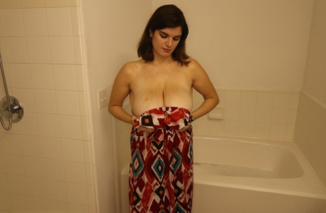 Брюнетка Дженни Ноубл массирует свои большие натуральные сиськи и член в ванной