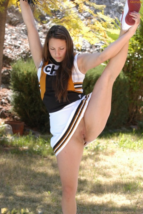 Naughty cheerleader Michelle flashes a pantyless upskirt outdoors