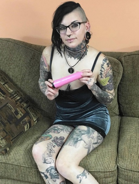 Brunette amateur covered in tattoos Tank toying her hungry pussy on the sofa
