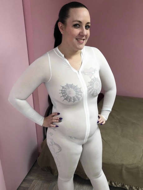 Tattooed MILF Selena Sky masturbating with a toy in her white catsuit