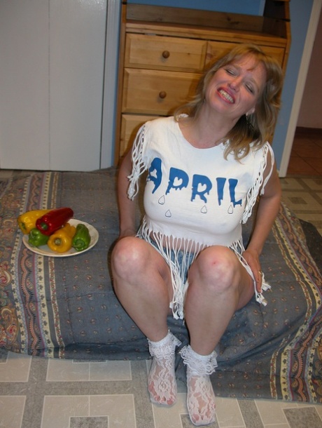Naughty MILF April Showers pleasures her shaved pussy with veggies