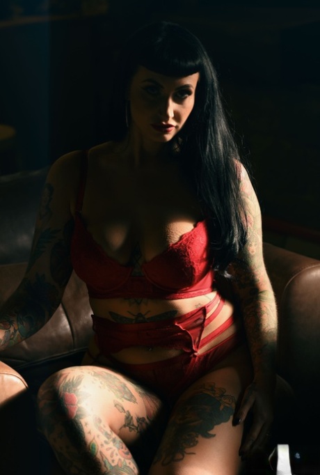 Tattooed babe Cherrie Pie exposes her big tits while teasing in red lingerie