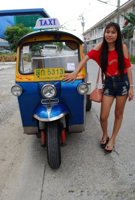 Une jolie femme asiatique monte dans un tuk tuk tout en montrant ses jambes chaudes en short.