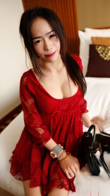 Hot Asian shemale bares her lovely tits while teasing in a sexy red dress