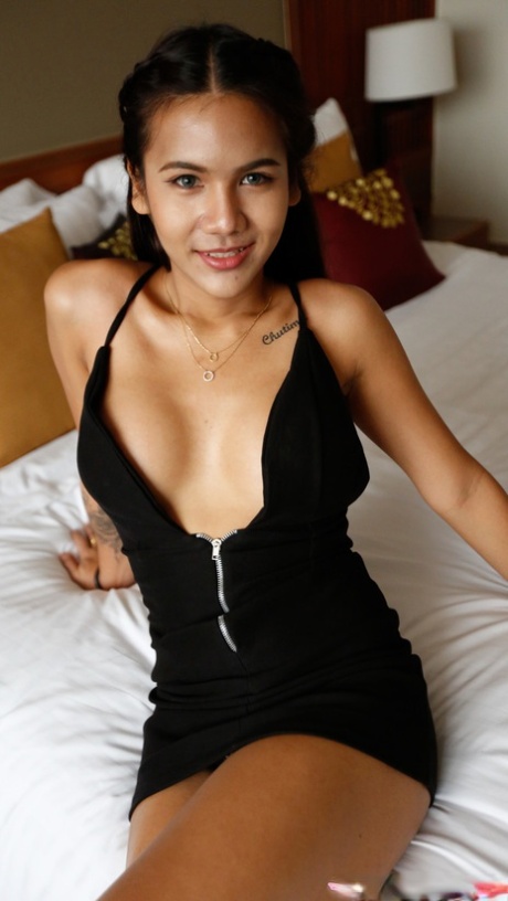 Tess B, jeune asiatique brune, montre ses gros seins et pose dans une chambre d'hôtel