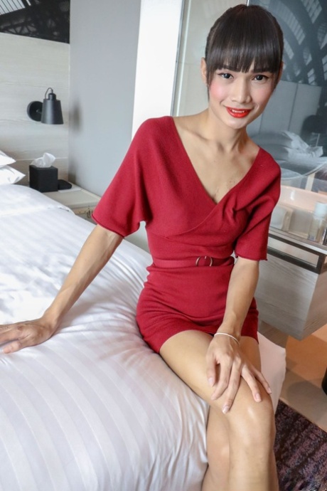 Brunette Asian shemale Mei tar av seg den røde kjolen og poserer i underbukser