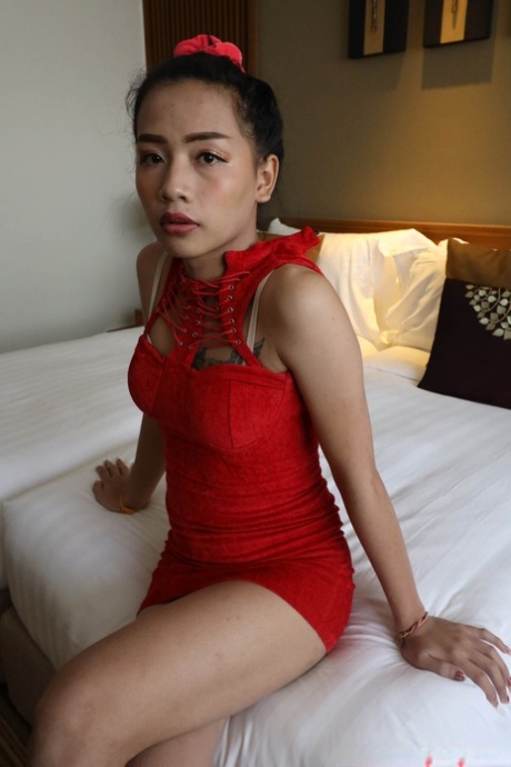 Petite Asian shemale in a red dress flashes her undies before sucking a dick