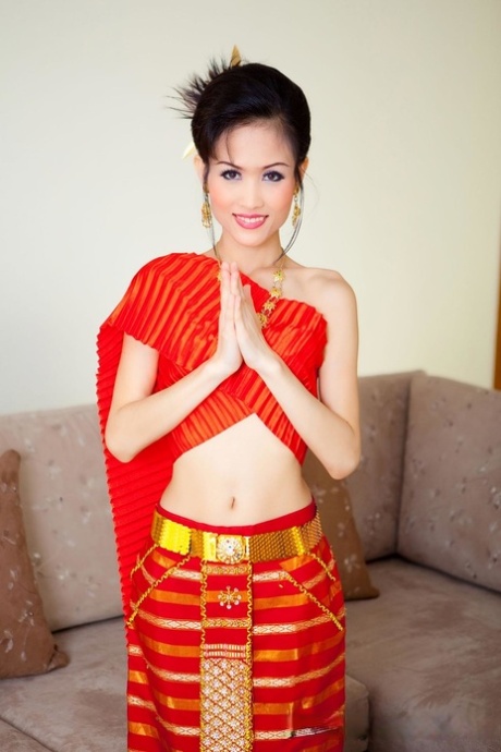 A doce modelo tailandesa Nana larga o seu traje tradicional e posa nua