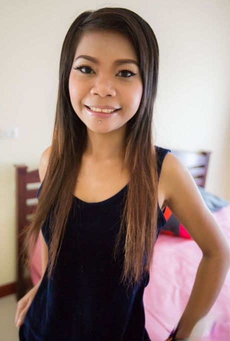 Thai Babe Min entledigt sich ihrer Kleidung und zeigt ihre schlanke Figur auf dem Bett