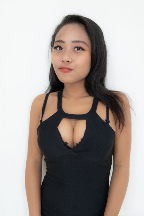 La sexy prostituta asiatica Joylyn si spoglia del vestito e della lingerie e posa nuda