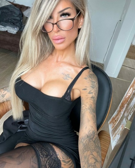 Nena glamorosa se burla de sus grandes tetas mientras muestra sus tatuajes