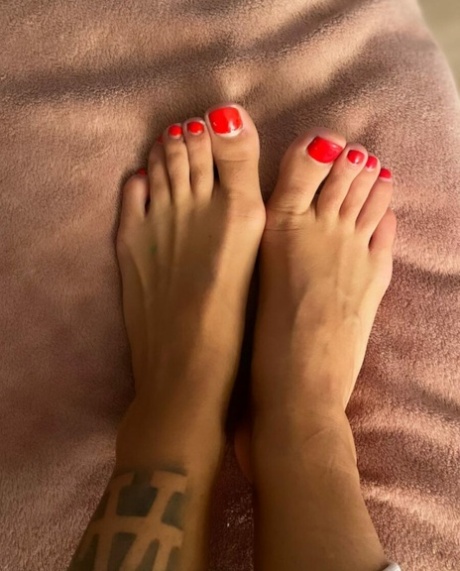 Le bébé tatoué Jacky montre ses pieds chauds, ses orteils peints sexy et ses courbes.