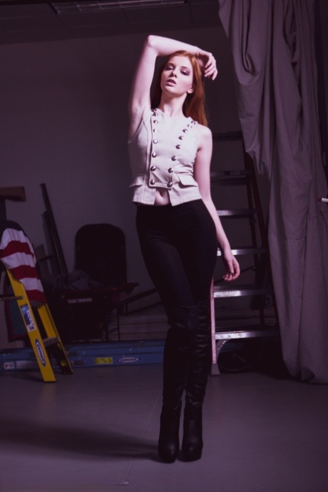 Das rothaarige Model Shaun Tia posiert in ihrer sexy Bluse, Hose und Highheels