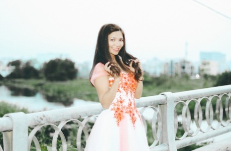 Une jeune fille sexy pose dans une robe magnifique et avec de belles fleurs en plein air.