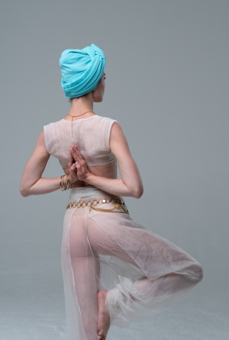 La beauté naturelle pose dans sa tenue transparente en faisant du yoga en solo.