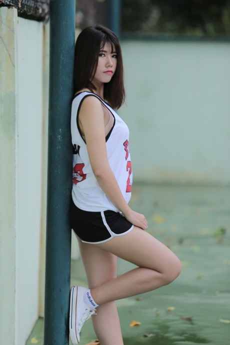 Hot Asian babe posing in her Bulls jersey and booty shorts on the tennis court