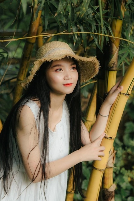 Gran mirada chica asiática posando en su vestido blanco en la hermosa naturaleza