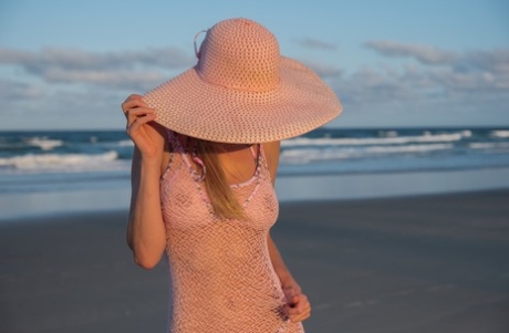 Sexy centerfold met pet pronkt met haar perfecte borsten en kutje op het strand