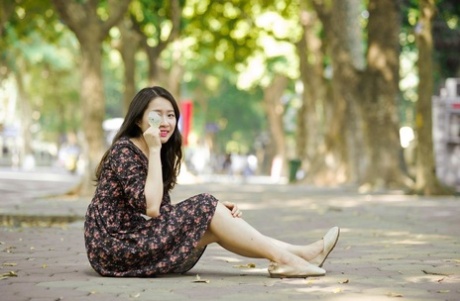 Snygga asiatiska brunettflickor som poserar i sina sommarklänningar på allmän plats