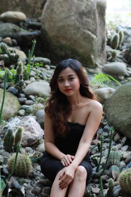 Mooi Aziatisch meisje pronkt met haar tengere lichaam in een sexy zwart jurkje