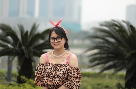 Voluptuous Asian babe with glasses posing in her leopard outfit in public