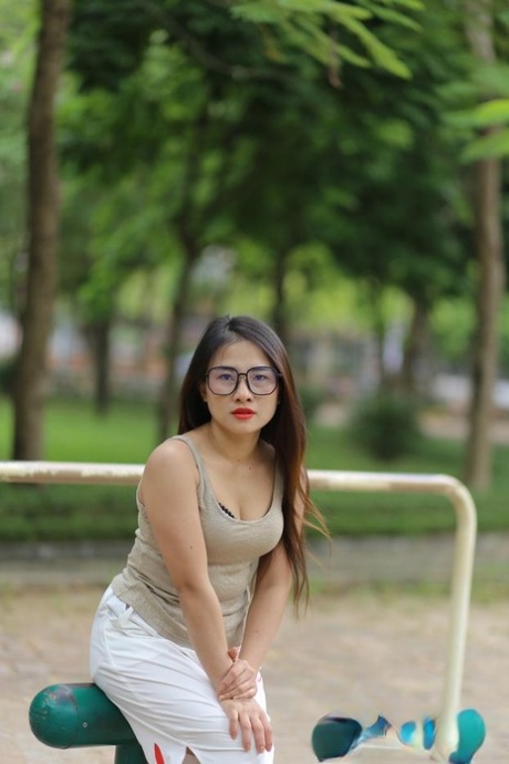 Impresionante modelo asiática con gafas Elena posando seductoramente en público