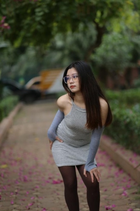 Glamorous Asian girl with glasses Natalia poses in her sexy dress outside