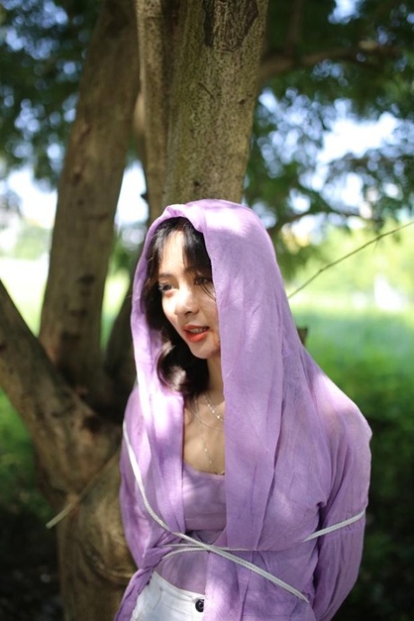 Asian seductress Nhatle posing in her amazing Halloween costume outdoors