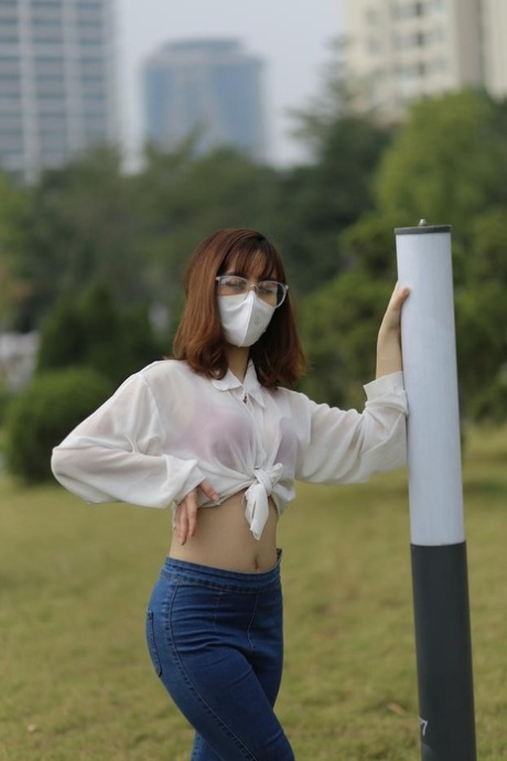 Redheaded Asian girl with a mask posing in her white top & tight jeans outside