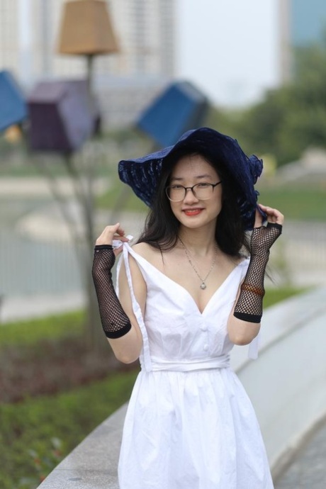 Nerdy Asian model Natalia posing in her white elegant dress outdoors