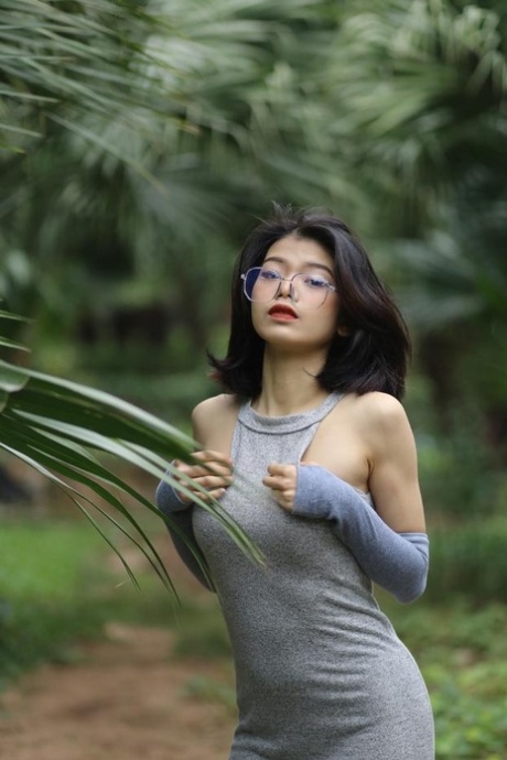 Beautiful Asian girl with glasses Irena posing in her lovely dress in nature