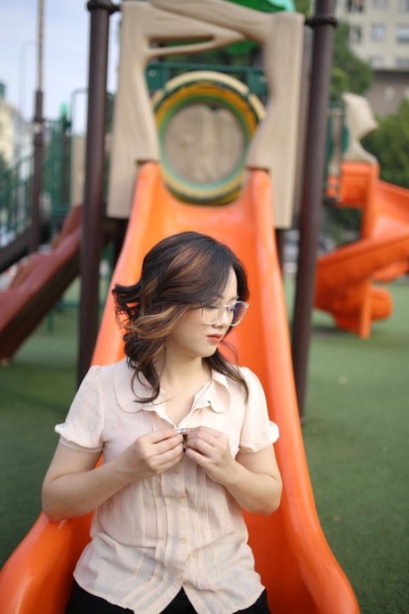 Little Asian girl with glasses exposing her cute cleavage in public