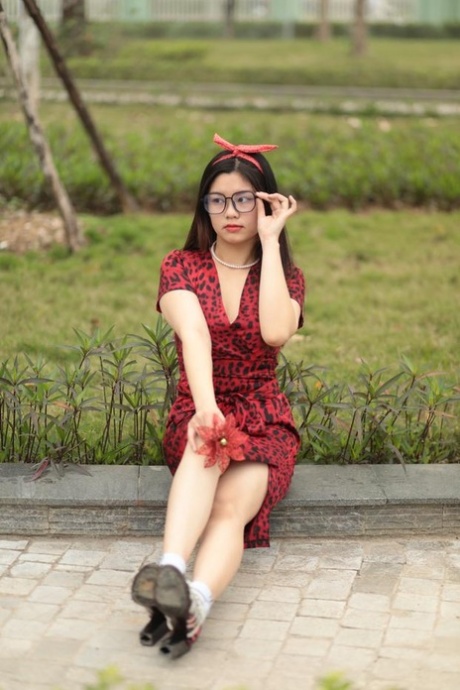 Nerdy Asian babe Natalia posing in her red summer dress and high heels