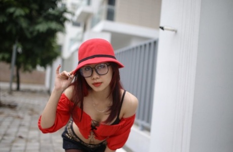 Little Asian girl with glasses Wanara poses in her provocative outfit outside