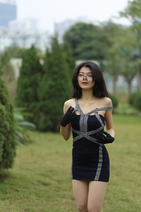 Little Asian seductress with glasses Irena poses in her tiny dress outside